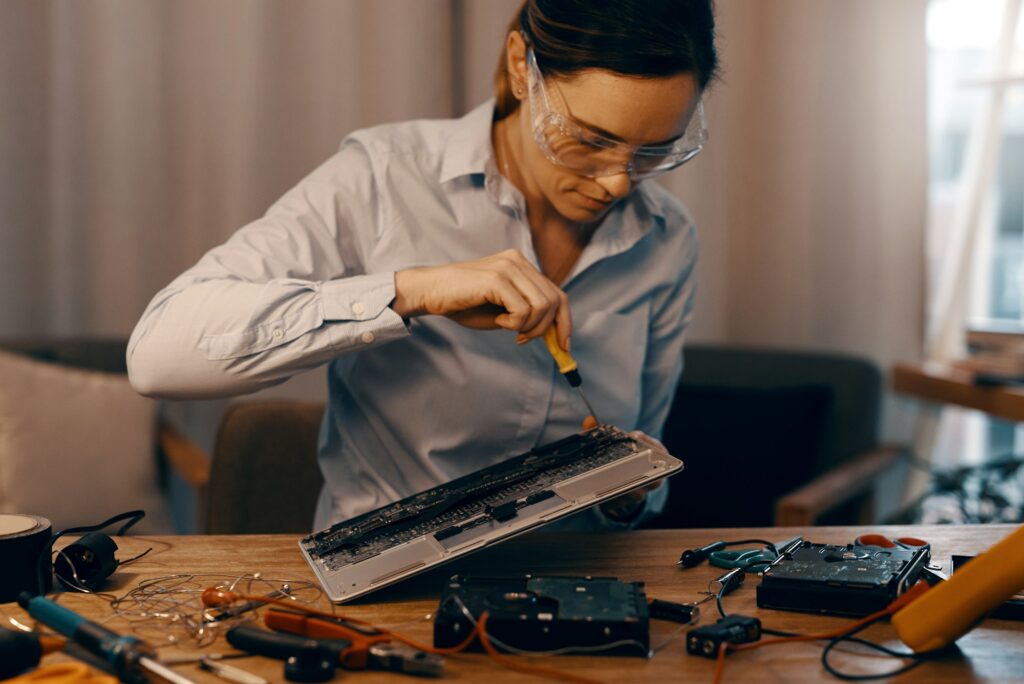 Cropped shot of an attractive young female computer technician repairing a laptop in her workshop