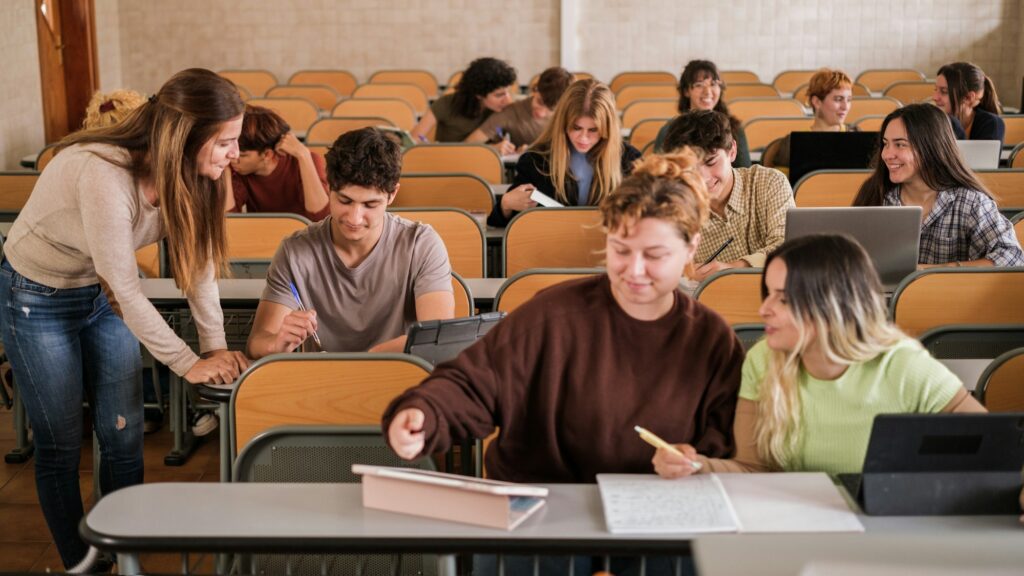 Teacher explaining individually to university students in a class