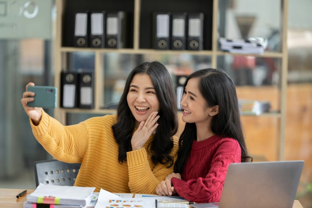 A picture of two businesswomen meeting televised via mobile.