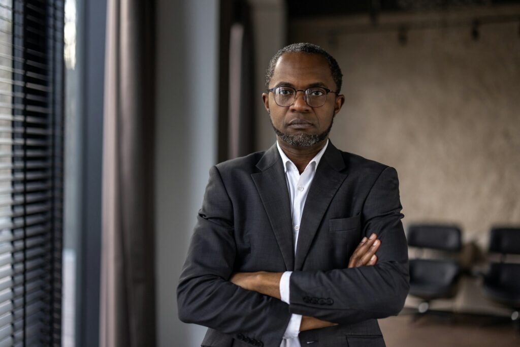 Confident businessman standing in office with arms crossed