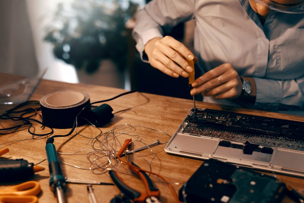 Cropped shot of an unrecognizable female computer technician repairing a laptop in her workshop