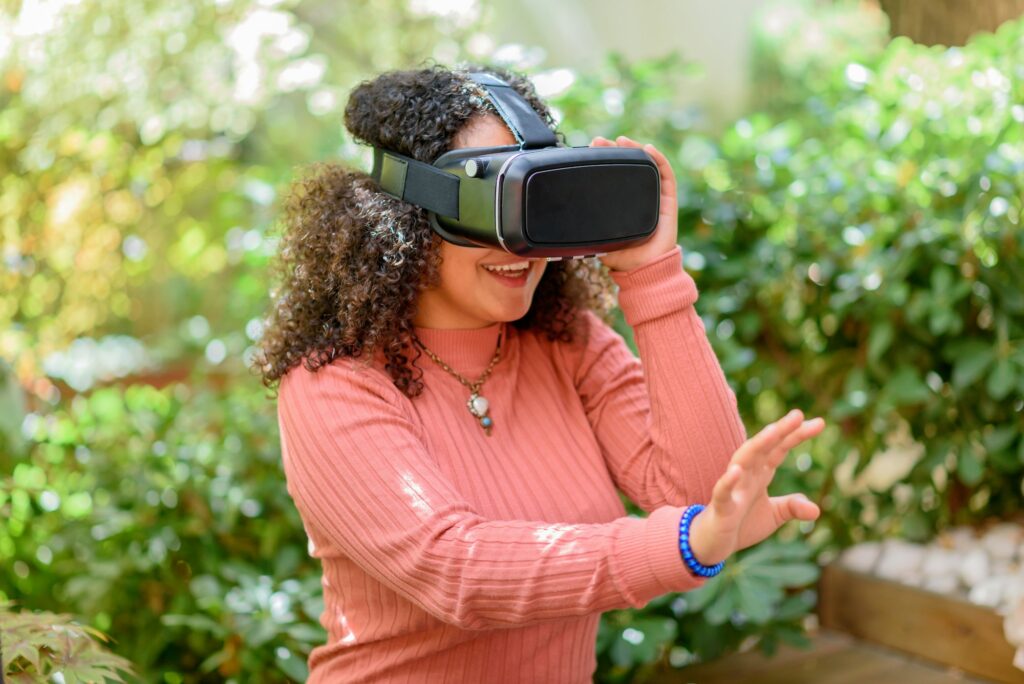 Young woman using a 3D VR headset outdoors on a patio